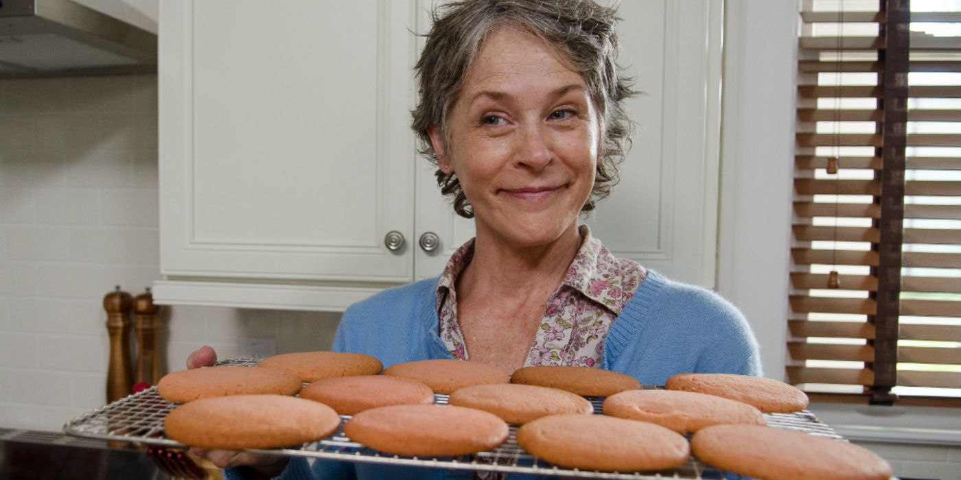 Carol sorrindo e segurando biscoitos em The Walking Dead. 