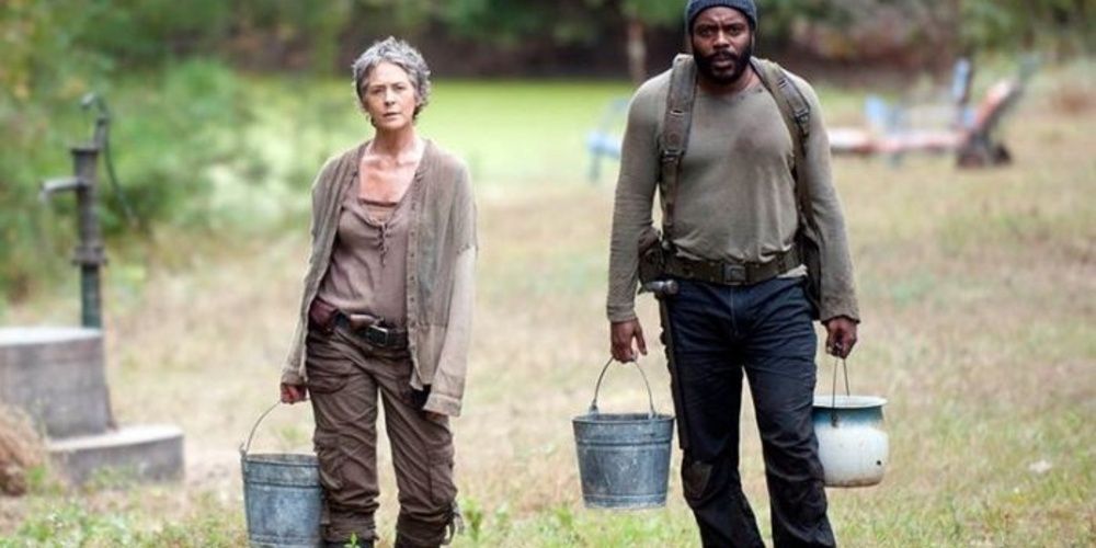 Carol e Tyreese carregando baldes de água em The Walking Dead 