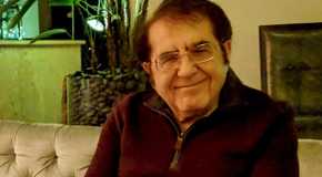 Dr. Now My 600 Lb Life sitting on couch smiling