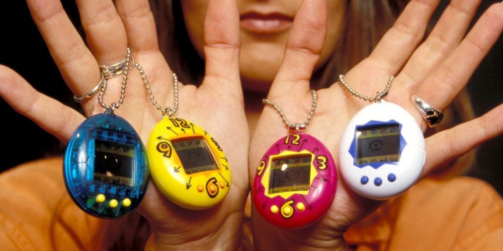 Four Tamagotchis being held in someones hands