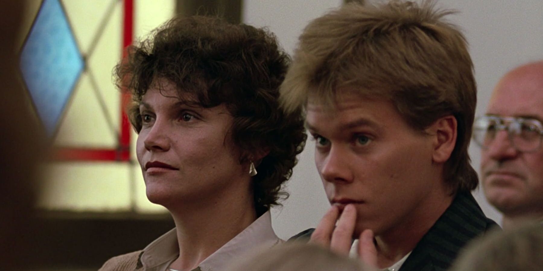 Frances Lee McCain and Kevin Bacon sitting inside a church in Footloose Cropped