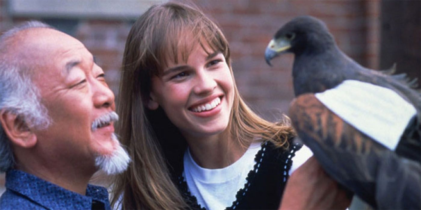 Hilary Swank em Karate Kid com o Sr. Miyagi, olhando para um pássaro.