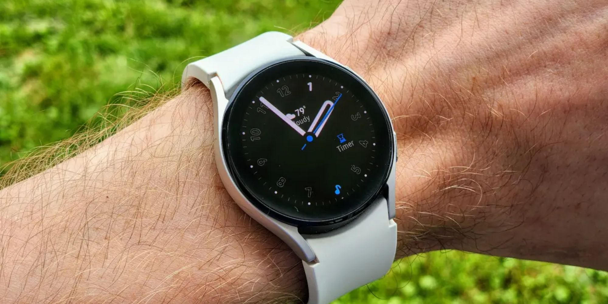 The Galaxy Watch 5 on a wrist shows the clock face.