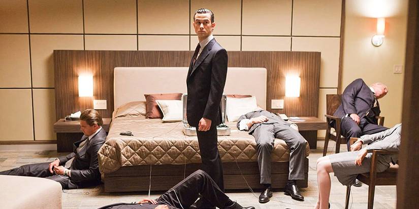Arthur stands around sleeping bodies in Inception