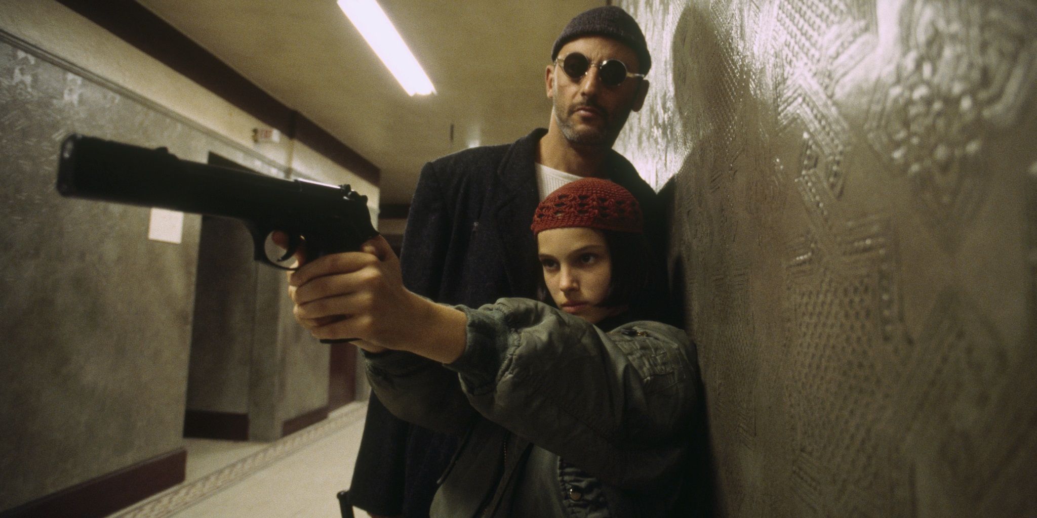 Jean Reno and Natalie Portman holding a gun in Léon Le Professionnel