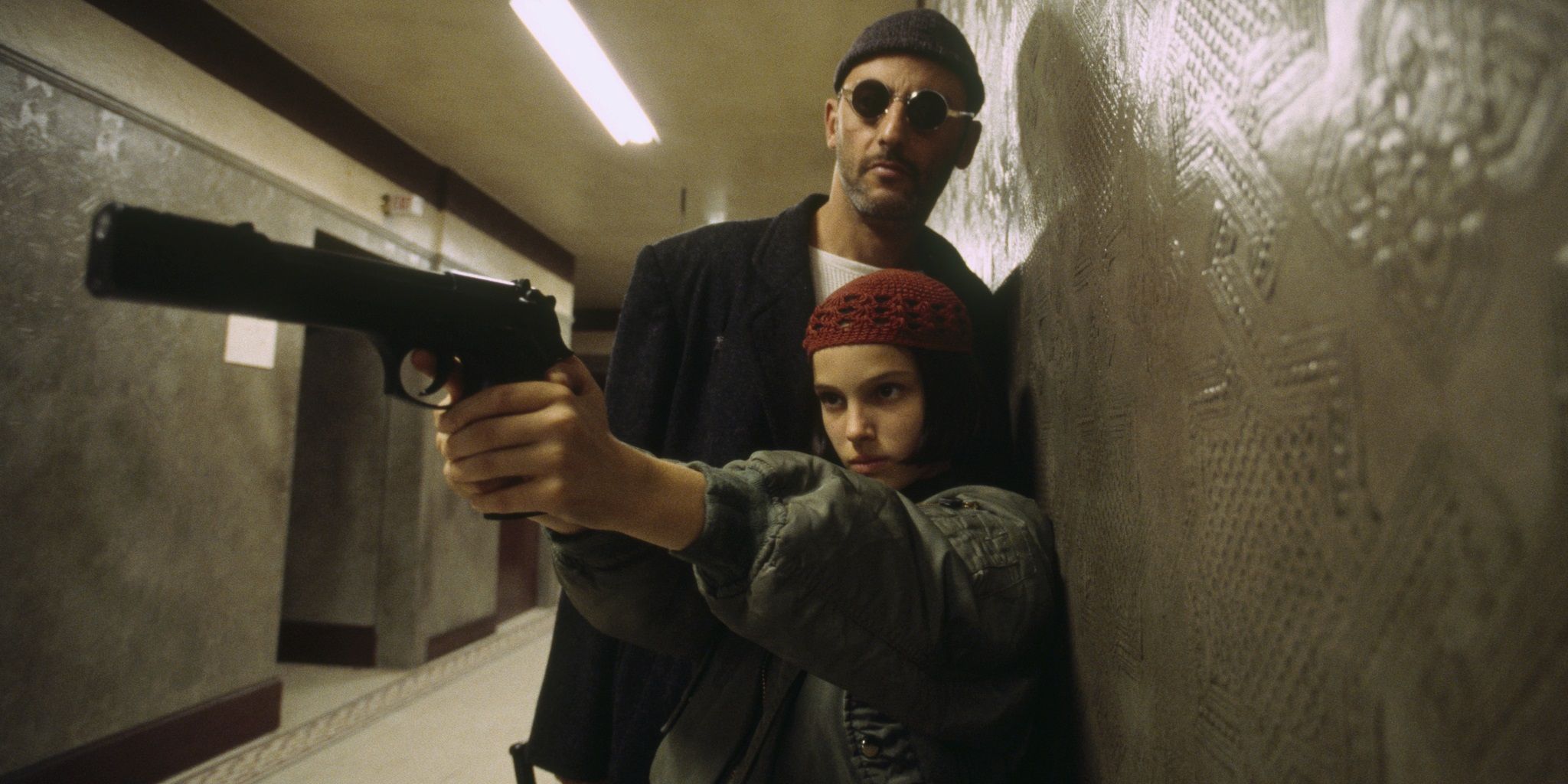 Jean Reno e Natalie Portman segurando uma arma em Leon The Professional