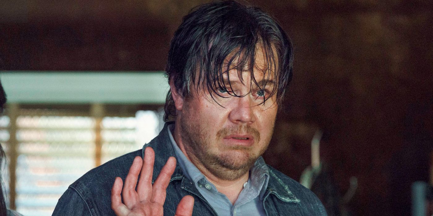 Josh McDermitt as Eugene in The Walking Dead looking pathetic with scraggly hair giving a splay-fingered wave