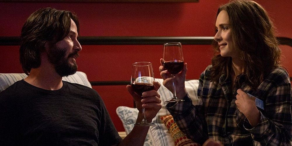 Keanu Reeves and Winona Ryder drinking wine in bed in Destination Wedding