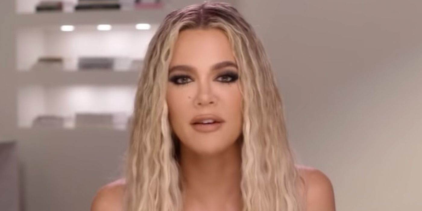 Khloé Kardashian from The Kardashians with blonde curly hair looking serious.
