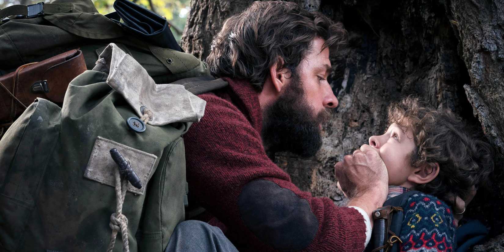 John Krasinski as Lee covers his son's mouth in A Quiet Place