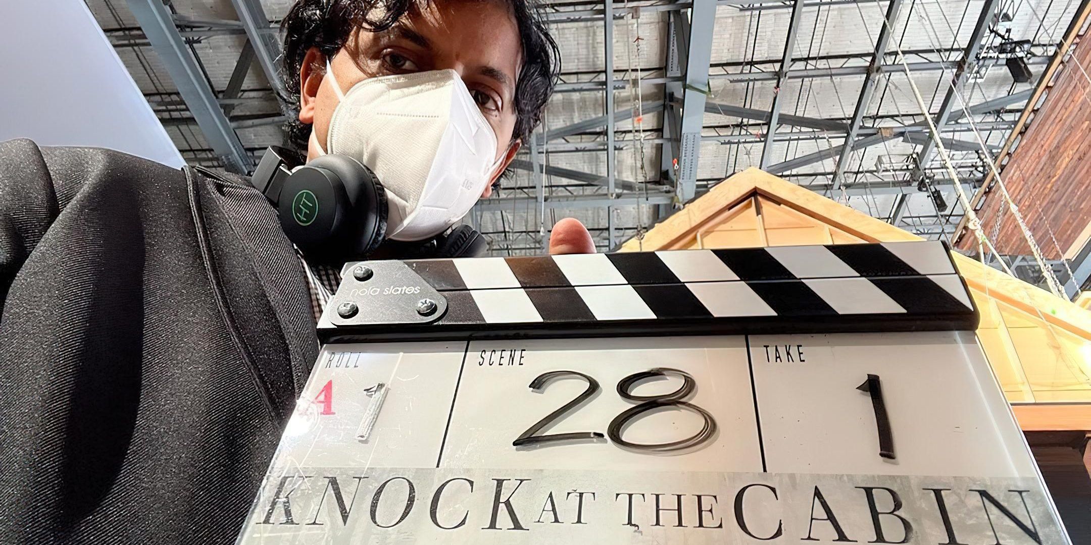 M Night Shyamalan with a clapperboard on the set of Knock at the Cabin