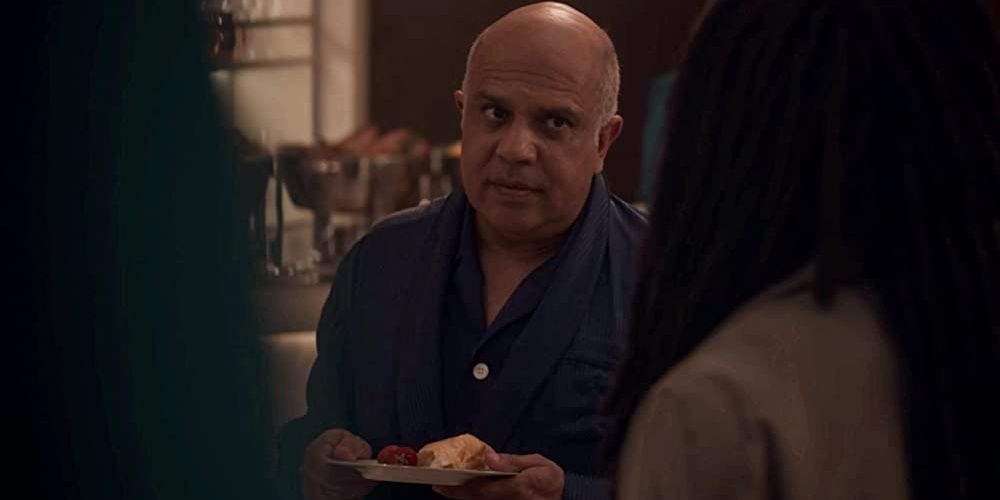 Manoj Sood holding a plate in Snowpiercer Cropped