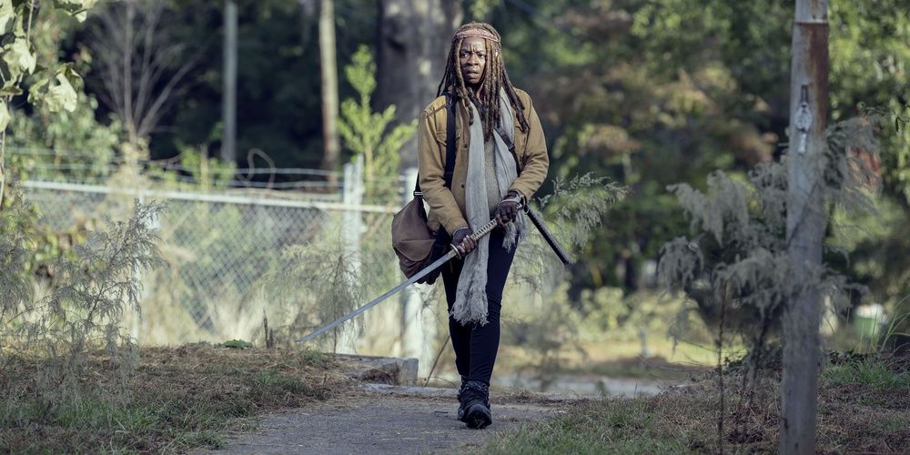 Michonne walking alone on a road in The Walking Dead