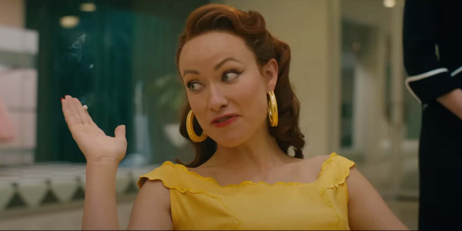 Olivia Wilde plays Bunny, who raises her hands and shrugs her shoulders in 