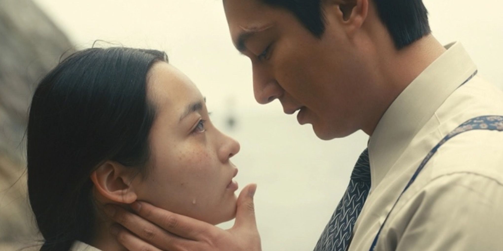 Two characters looking at each other in Pachinko (2022)