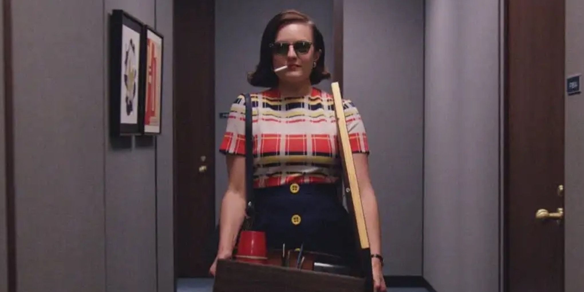 Peggy Olson (Elizabeth Moss) walking down the hallway with a box, sunglasses and a cigarette on Mad Men