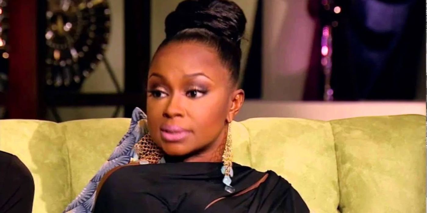 Phaedra in a black dress sitting on the couch of the reunion for RHOA