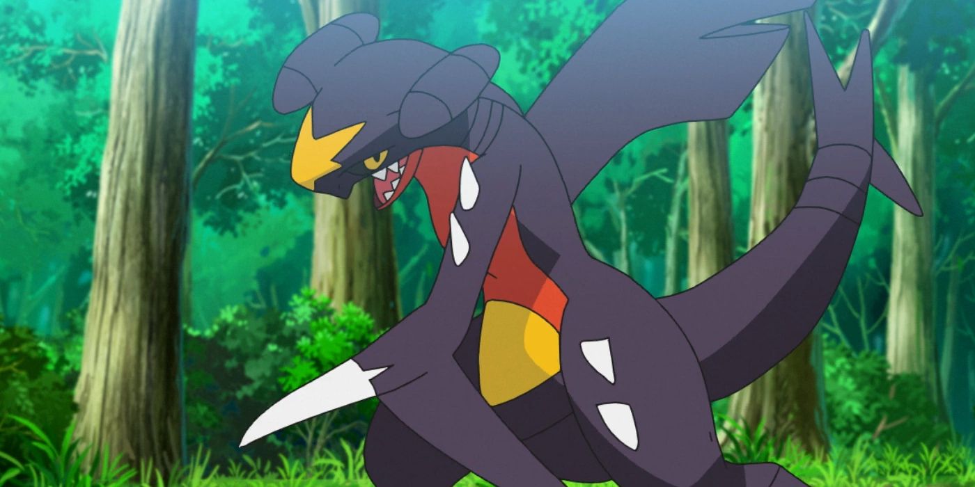 Garchomp from the Pokémon anime standing in a forested area.