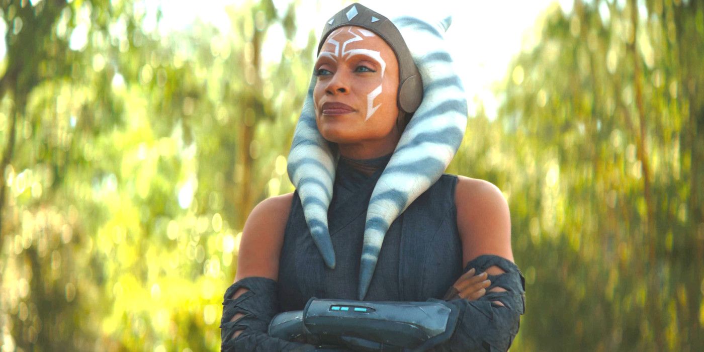 Rosario Dawson as Ahsoka Tano in Book of Boba Fett in the forest with her arms crossed looking somewhat smug