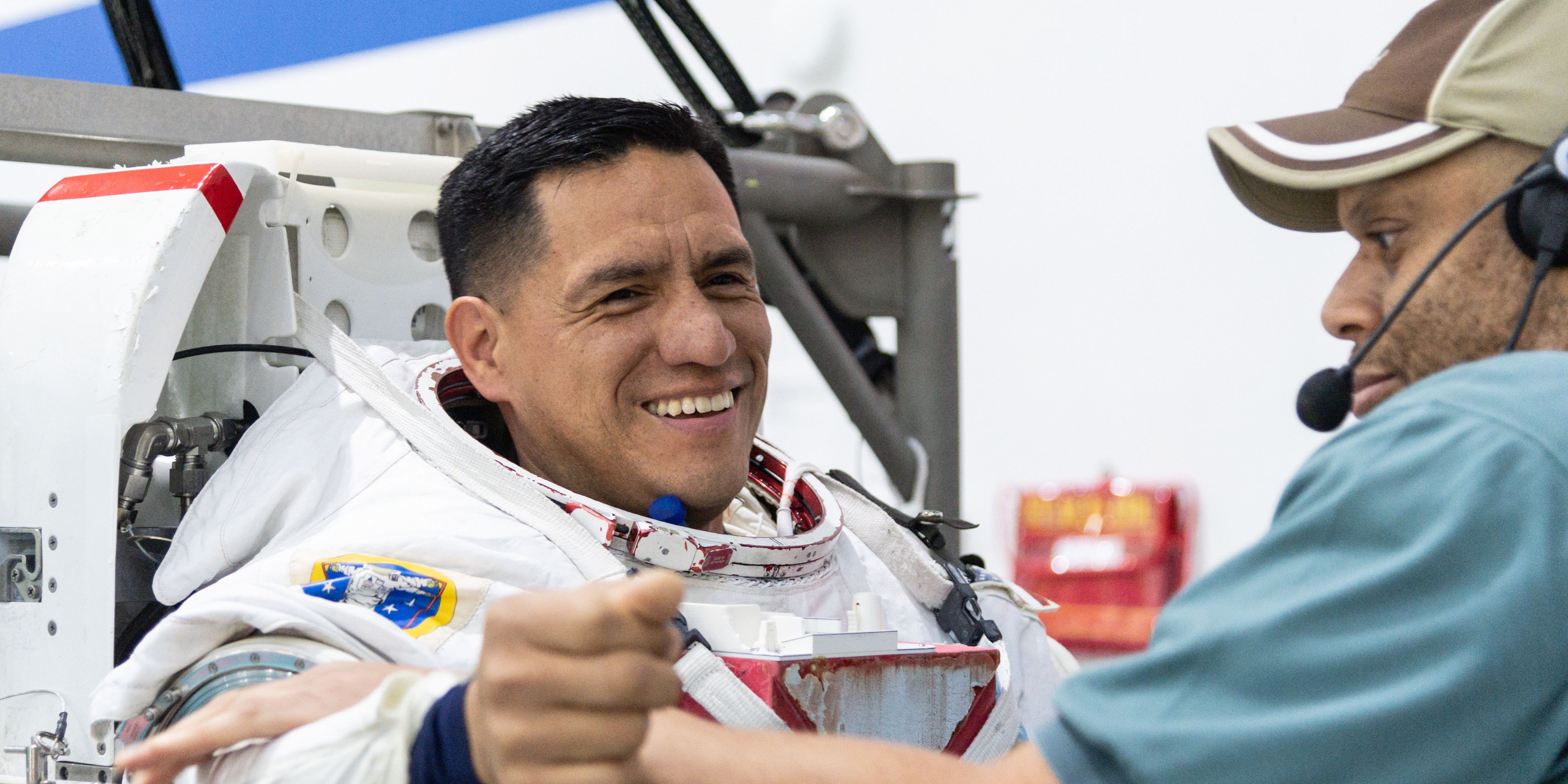 Frank Rubio recebe ajuda para vestir um traje espacial no Neutral Buoyancy Laboratory no Johnson Space Center da NASA em Houston para treinar para caminhadas espaciais