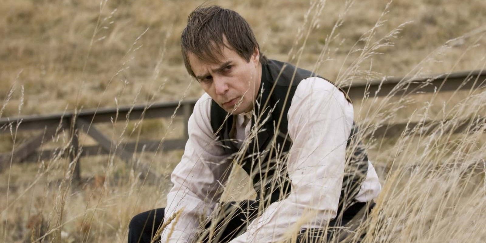 Sam Rockwell sitting in the fields in The Assassination Of Jesse James