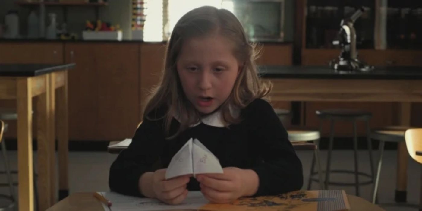 Tracy Tyler brincando com um pedaço de papel na aula em Stranger Things