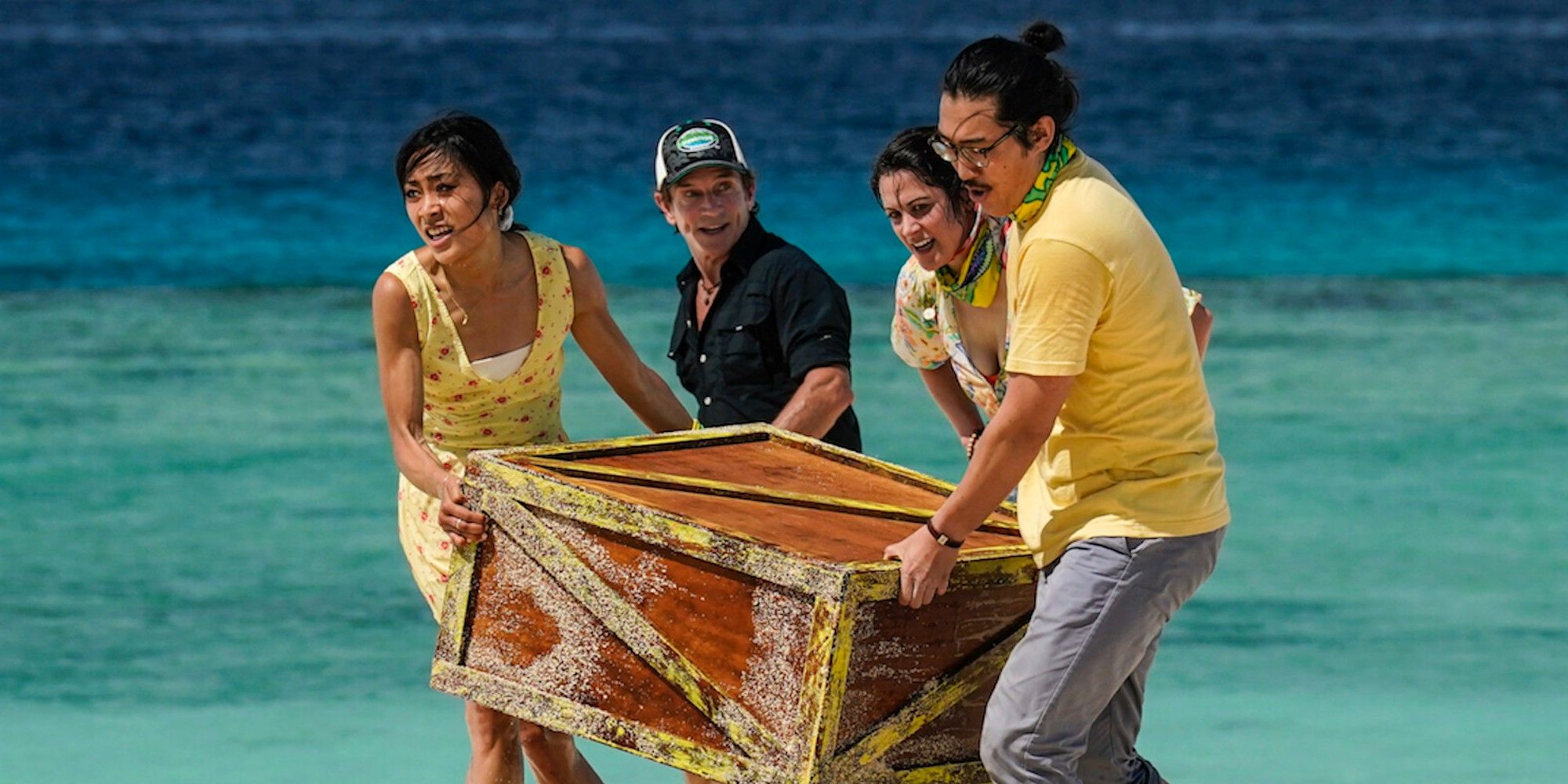 Survivor 43 cast shot in ocean with jeff probst and crate