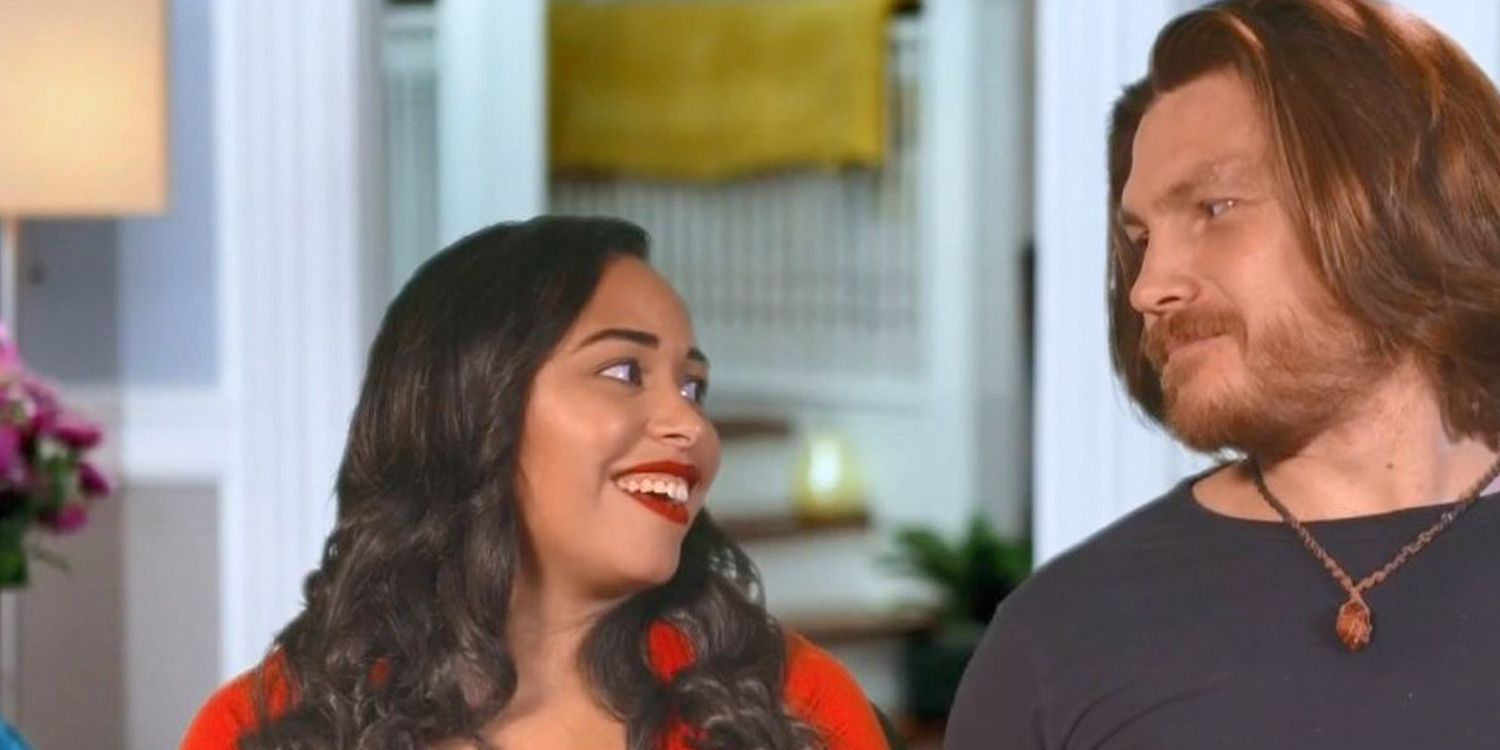 Syngin Colchester Looking at Tania Maduro smiling while wearing red dress on 90 Day Fiance