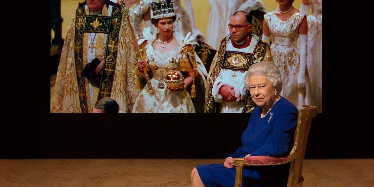An older Queen Elizabeth seated in front of an image of her coronation in The Coronation Documentary (2018)
