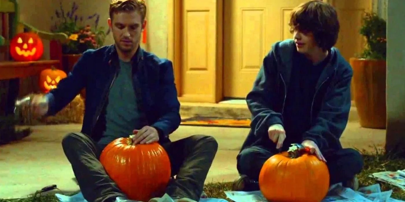 Two characters carving pumpkins and smiling in The Guest