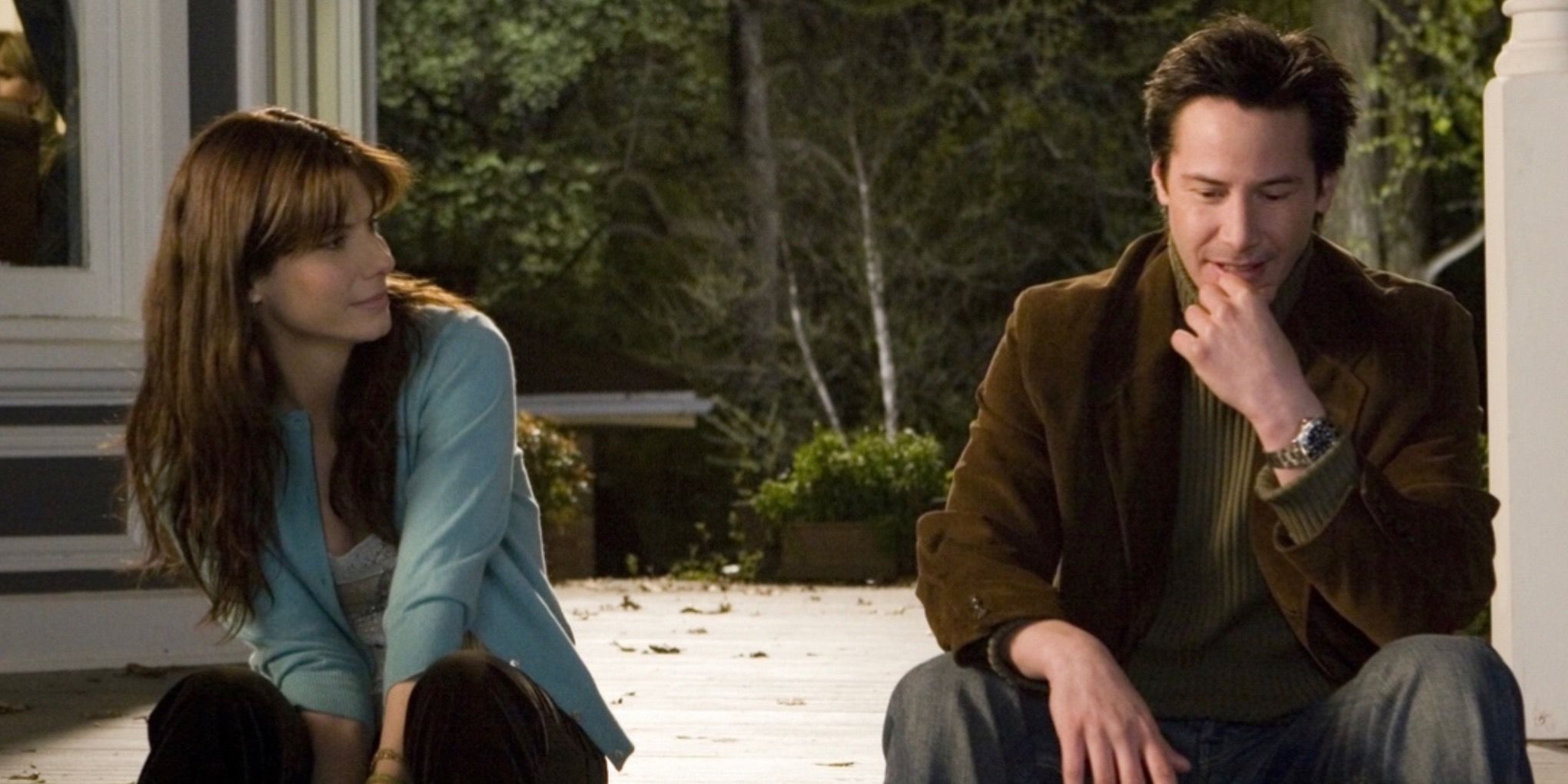 Keanu Reeves and Sandra Bullock sit together in The Lake House (2006)