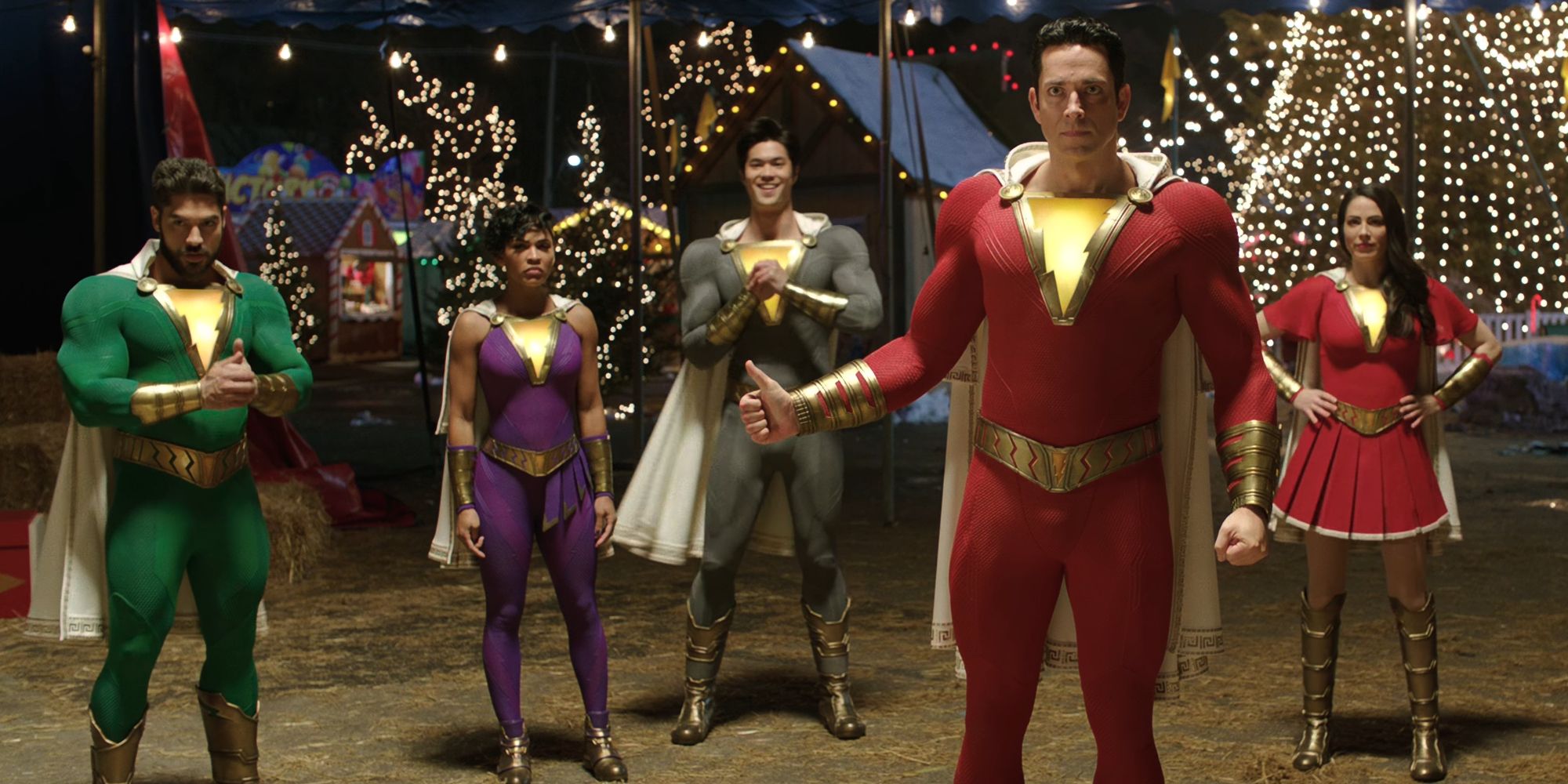 Zachary Levi giving a thumbs up as his family stands behind him in Shazam!