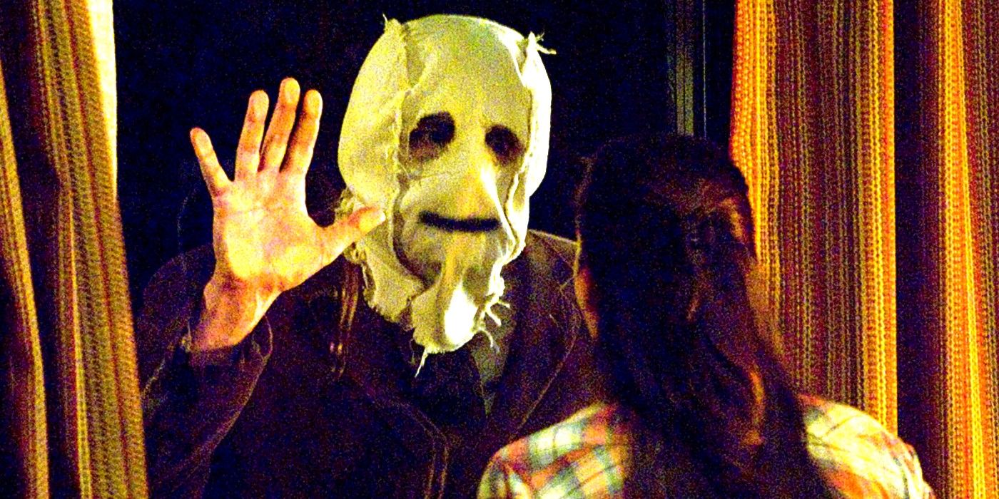 A masked killer waves in The Strangers