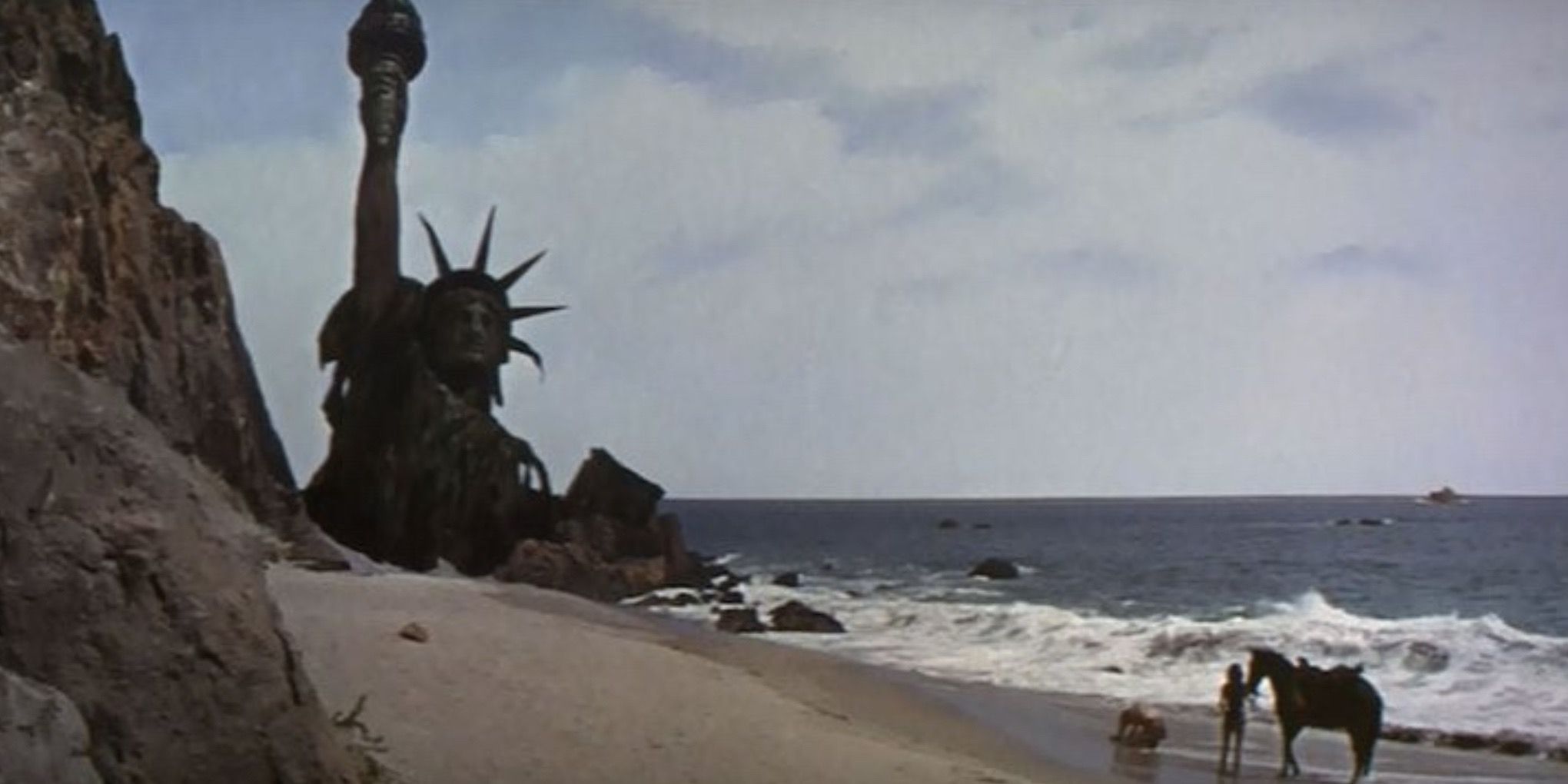 The destroyed Statue of Liberty rises out of the sand in Planet of the Apes 