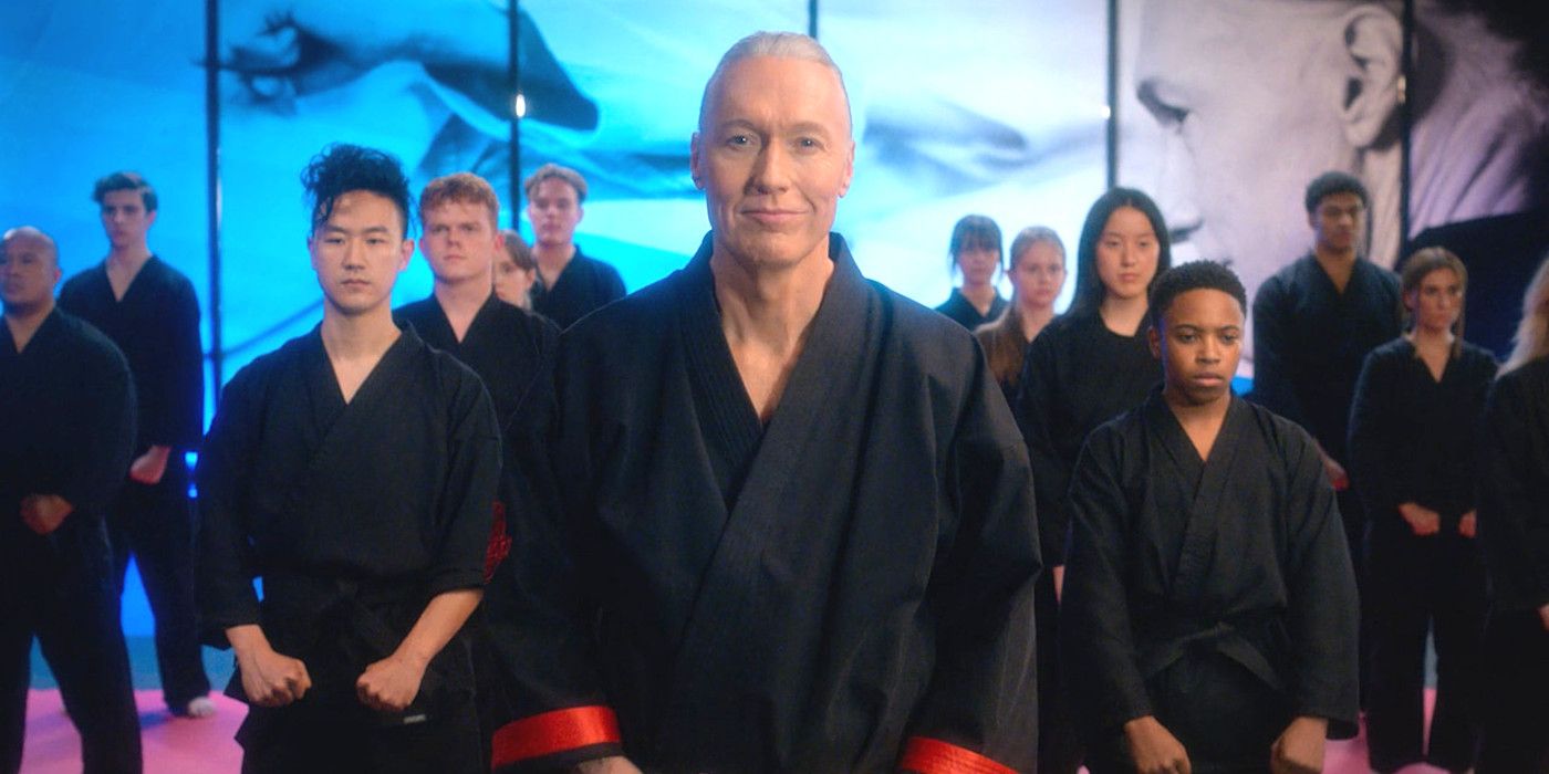 Thomas Ian Griffith as Terry Silver in Cobra Kai season 5 wearing a karate robe and standing in front of a group of his karate students in his elaborate dojo