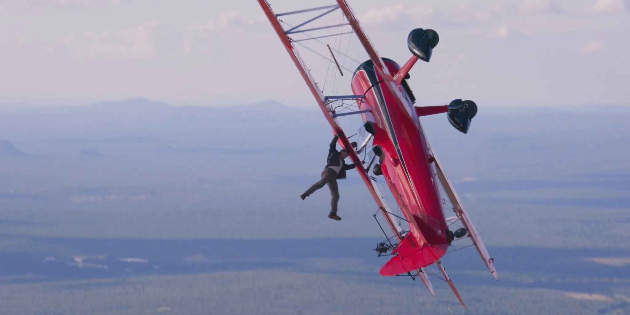 Tom Cruise dangling from a plane in a stunt from Mission Impossible Dead Reckoning Part One