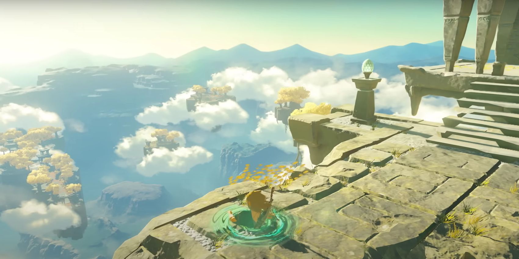 Link popping his head and shoulders out of a portal on the stone ground of a floating island in an early Tears of the Kingdom trailer.