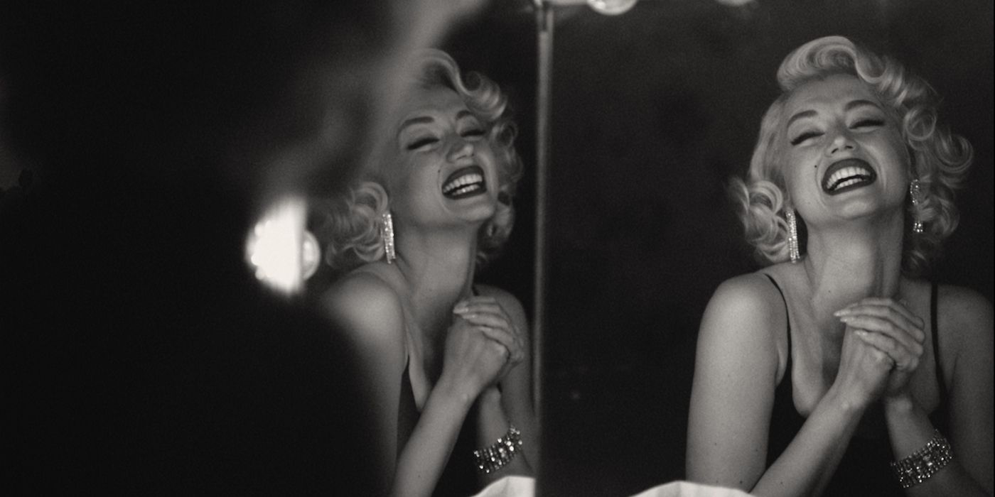 Ana de Armas as Marilyn Monroe smiling into a mirror in Blonde