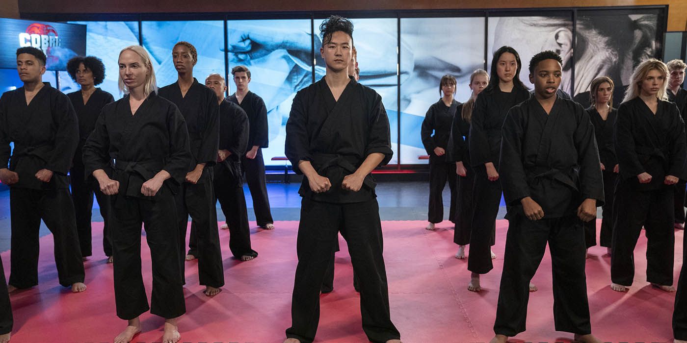The students in the Cobra Kai dojo standing at attention, in rows.