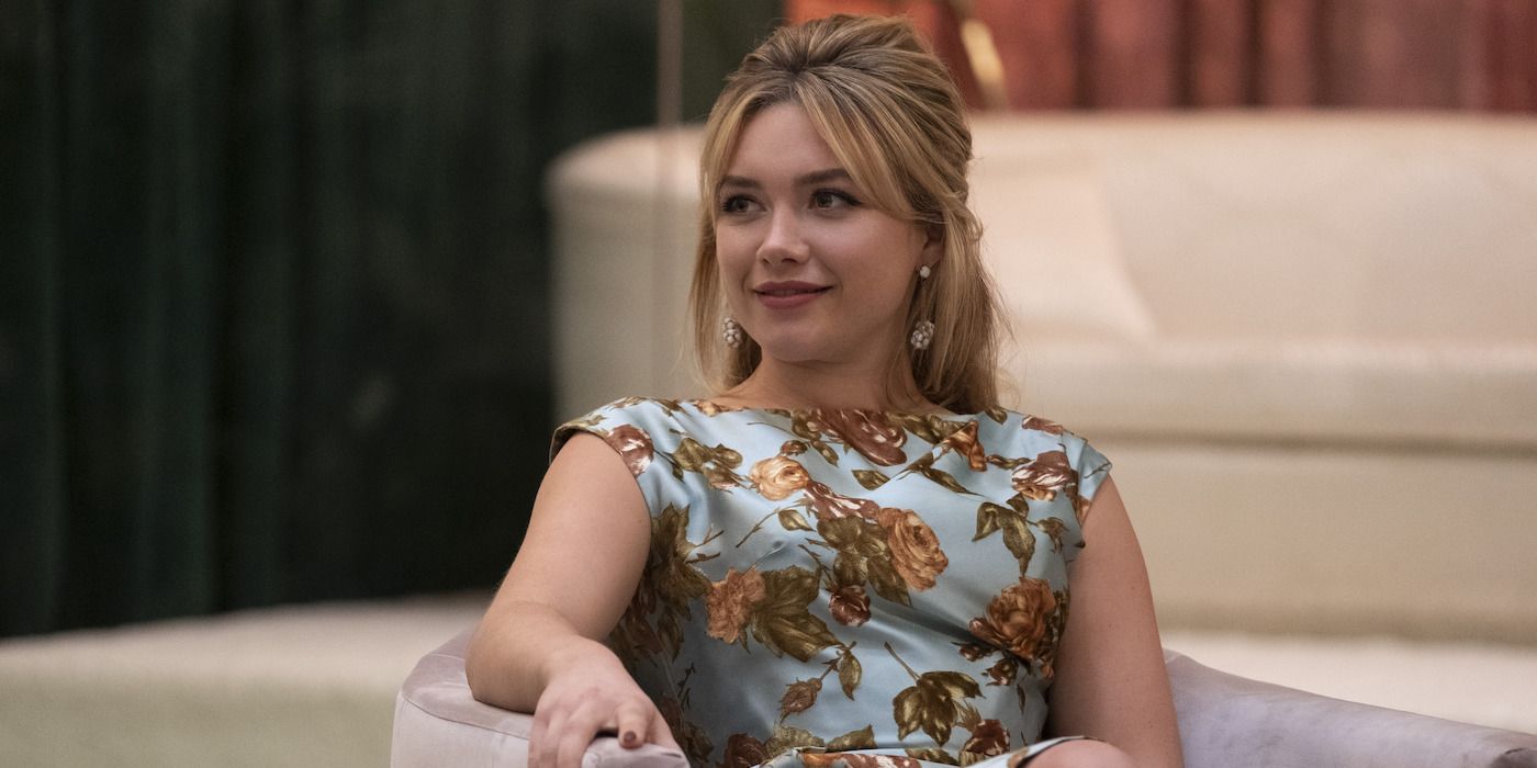 Florence Pugh with beehive hair sits in chair