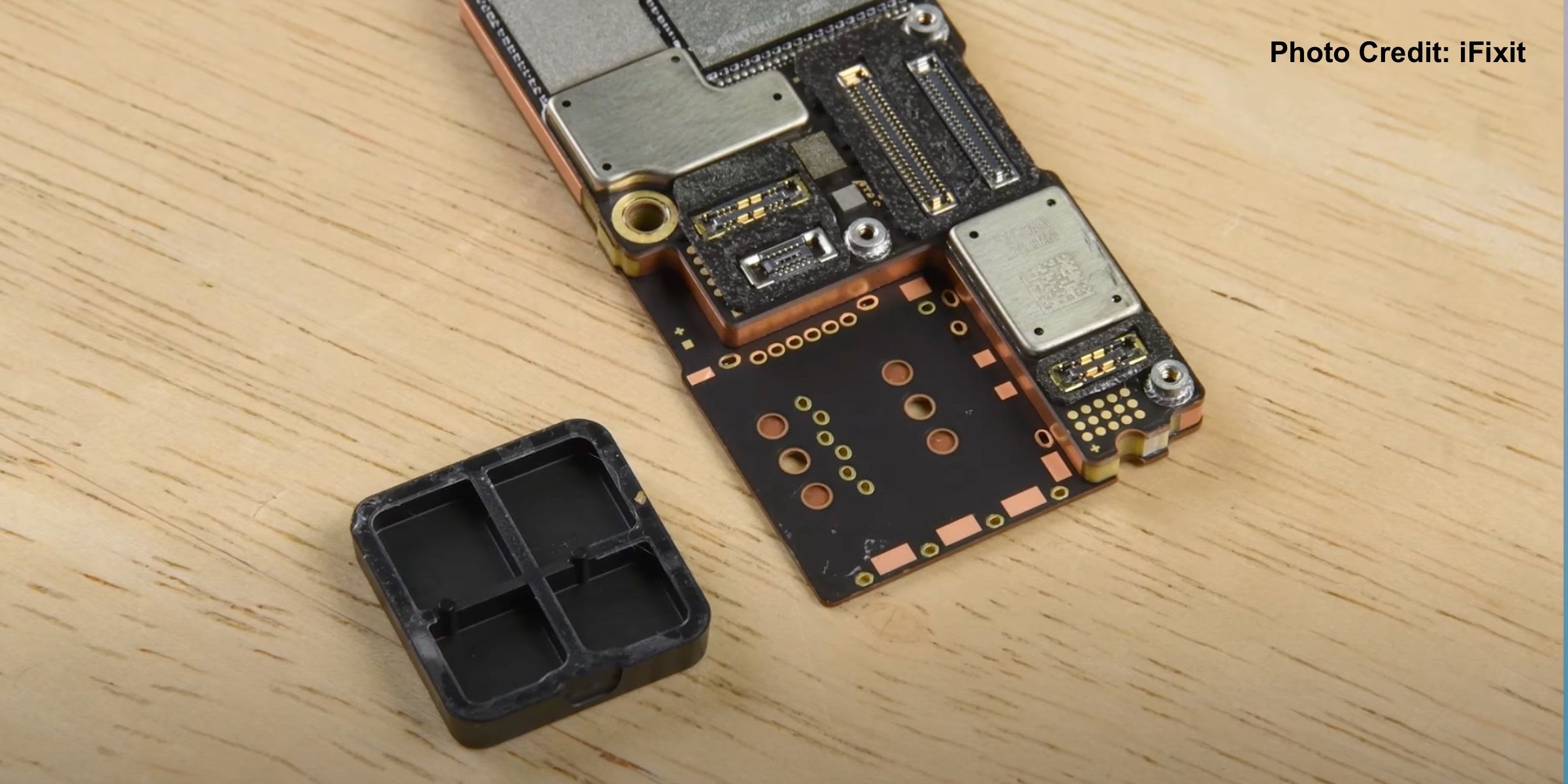 Teardown image showing SIM-card spacer in the iPhone 14 Pro Max.