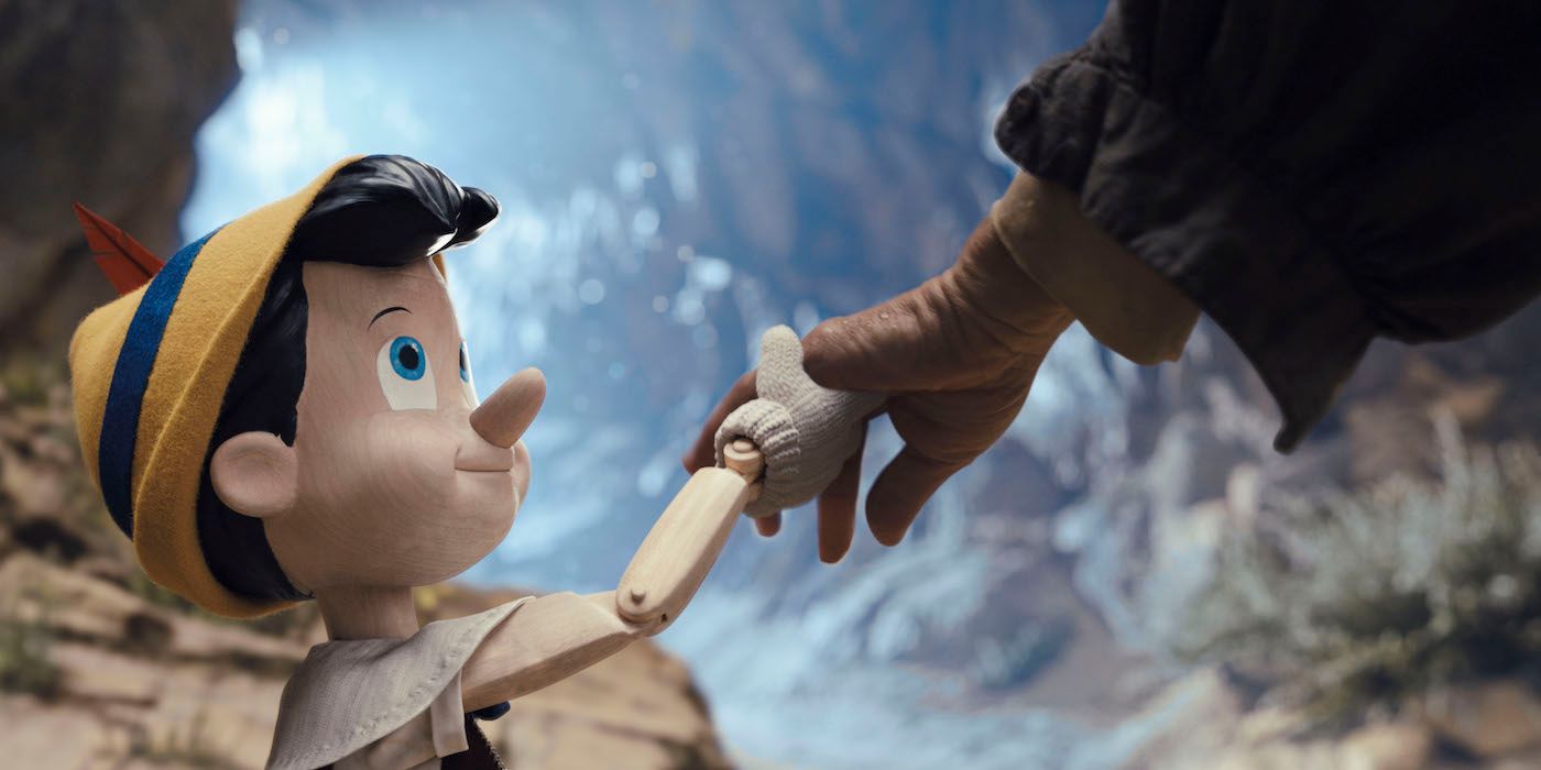 Benjamin Evan Ainsworth as Pinocchio holding Geppetto's hand in Pinocchio (2022)