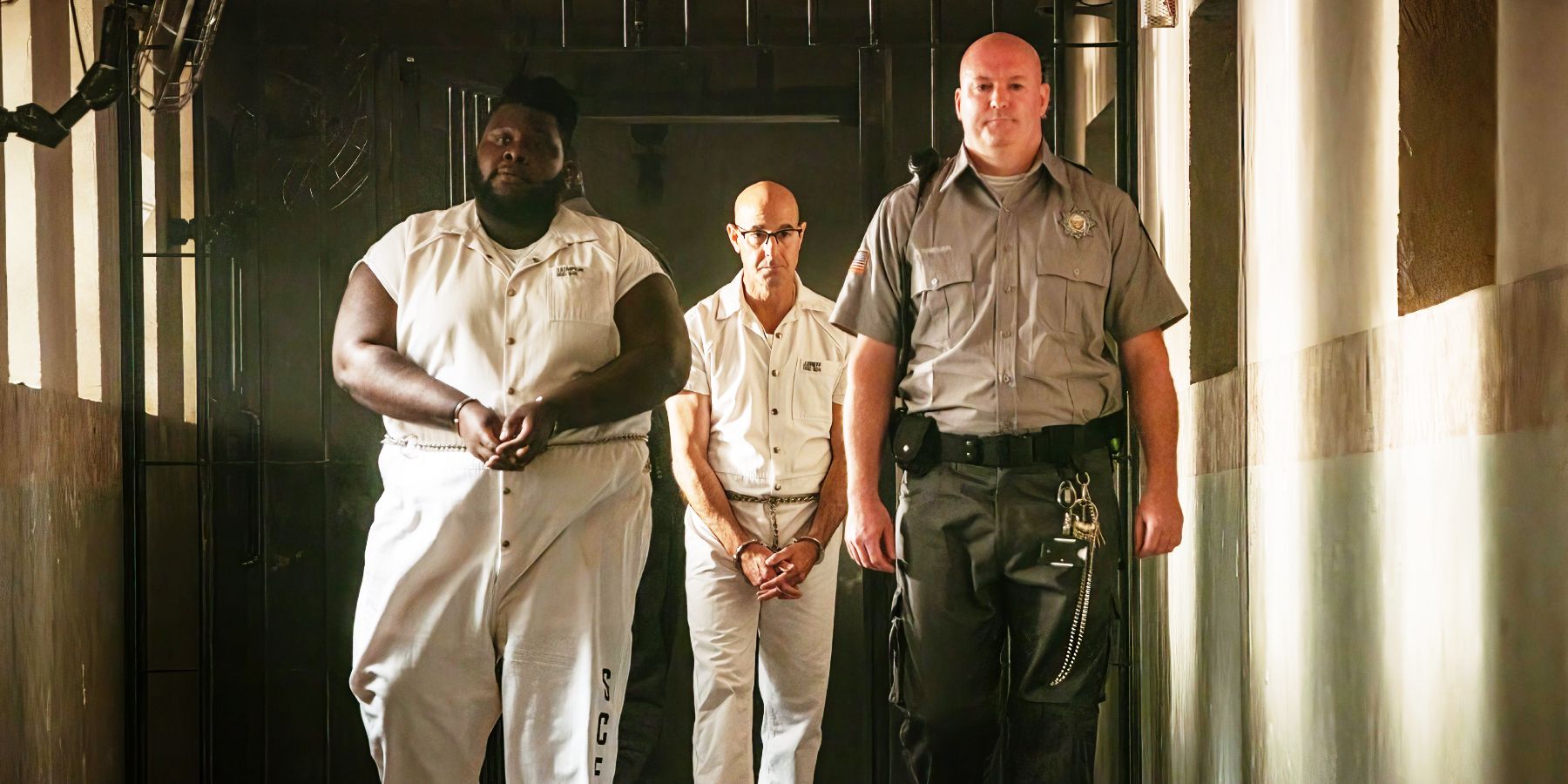 Stanley Tucci and Atkins Estimond as Jefferson Grieff and Dillon walking through prison in Inside Man