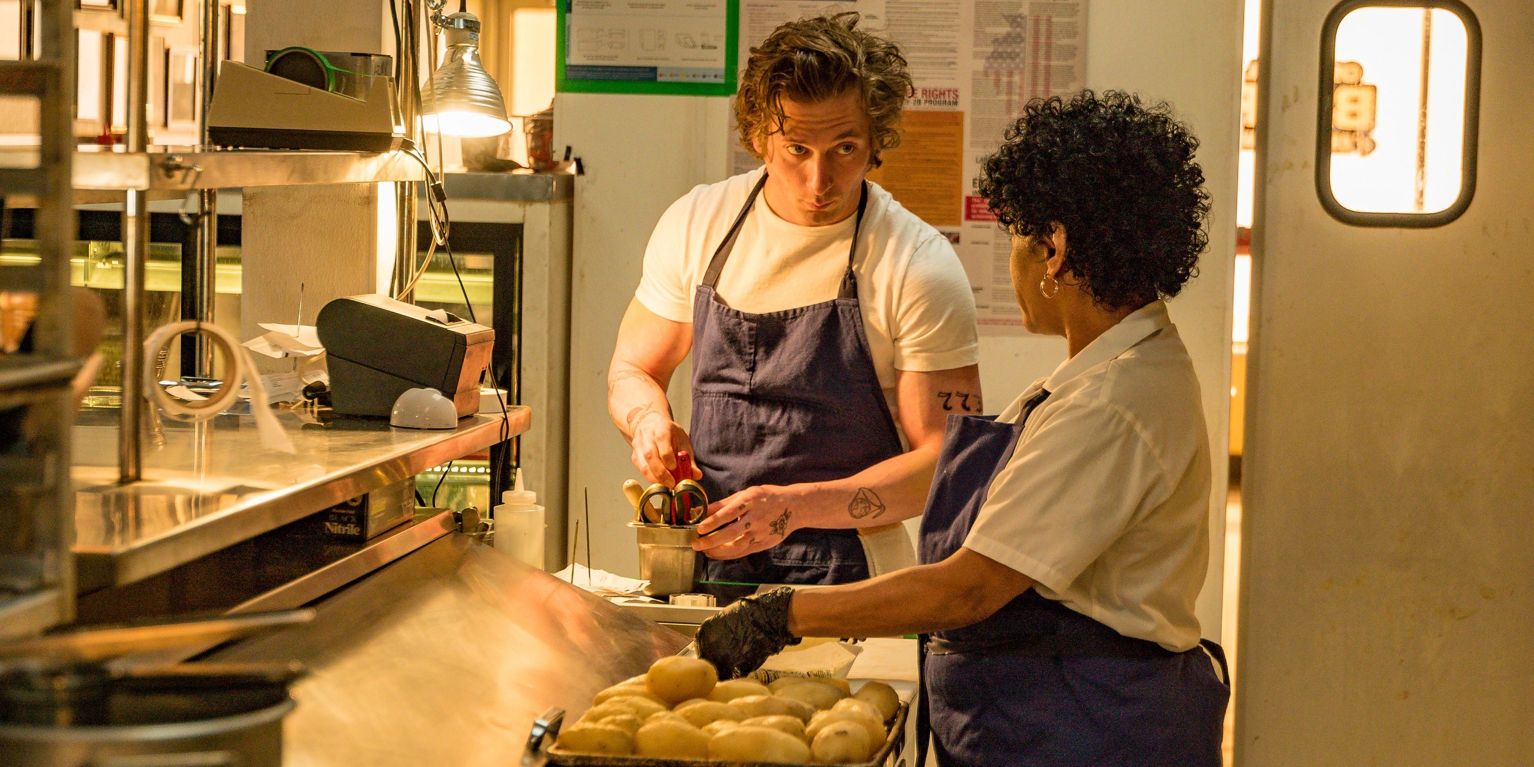 Um homem e uma mulher trabalhando em uma cozinha em The Bear 