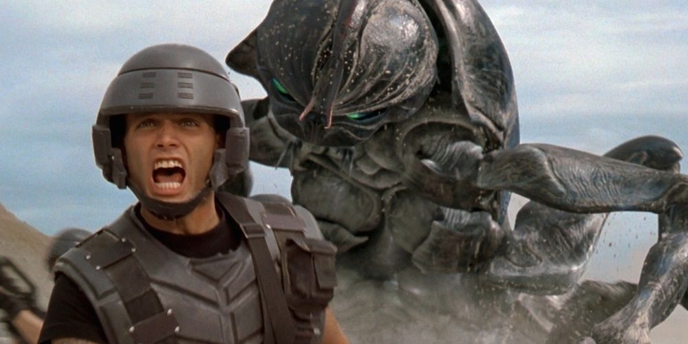 A soldier flees from a giant insect in Starship Troopers