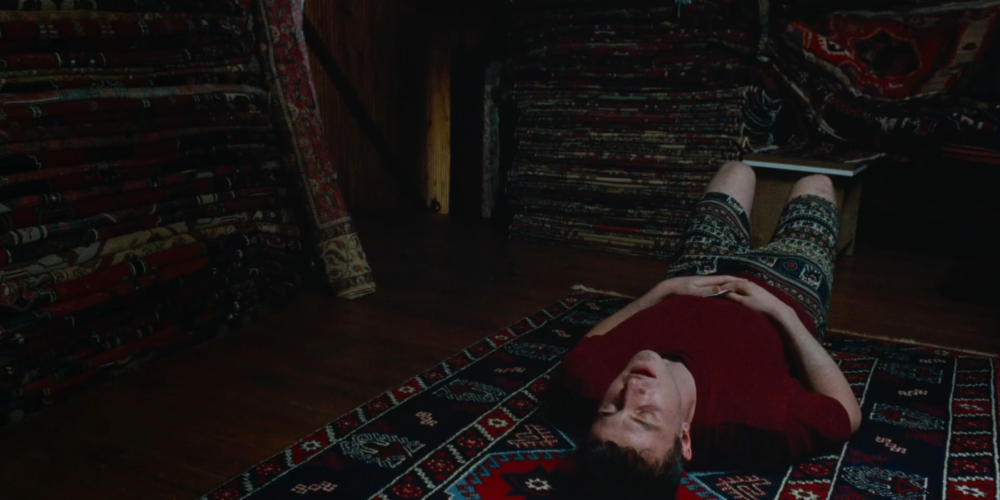 Calum lying on a rug in Aftersun