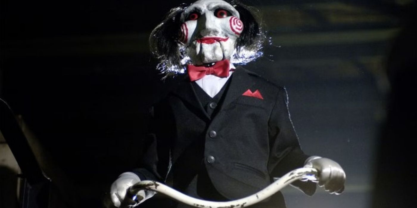 Billy the Puppet rides in Saw
