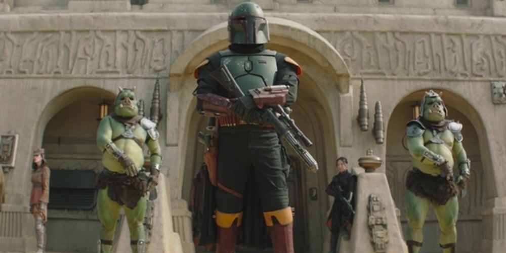 Boba Fett stands with two aliens in The Book Of Boba Fett