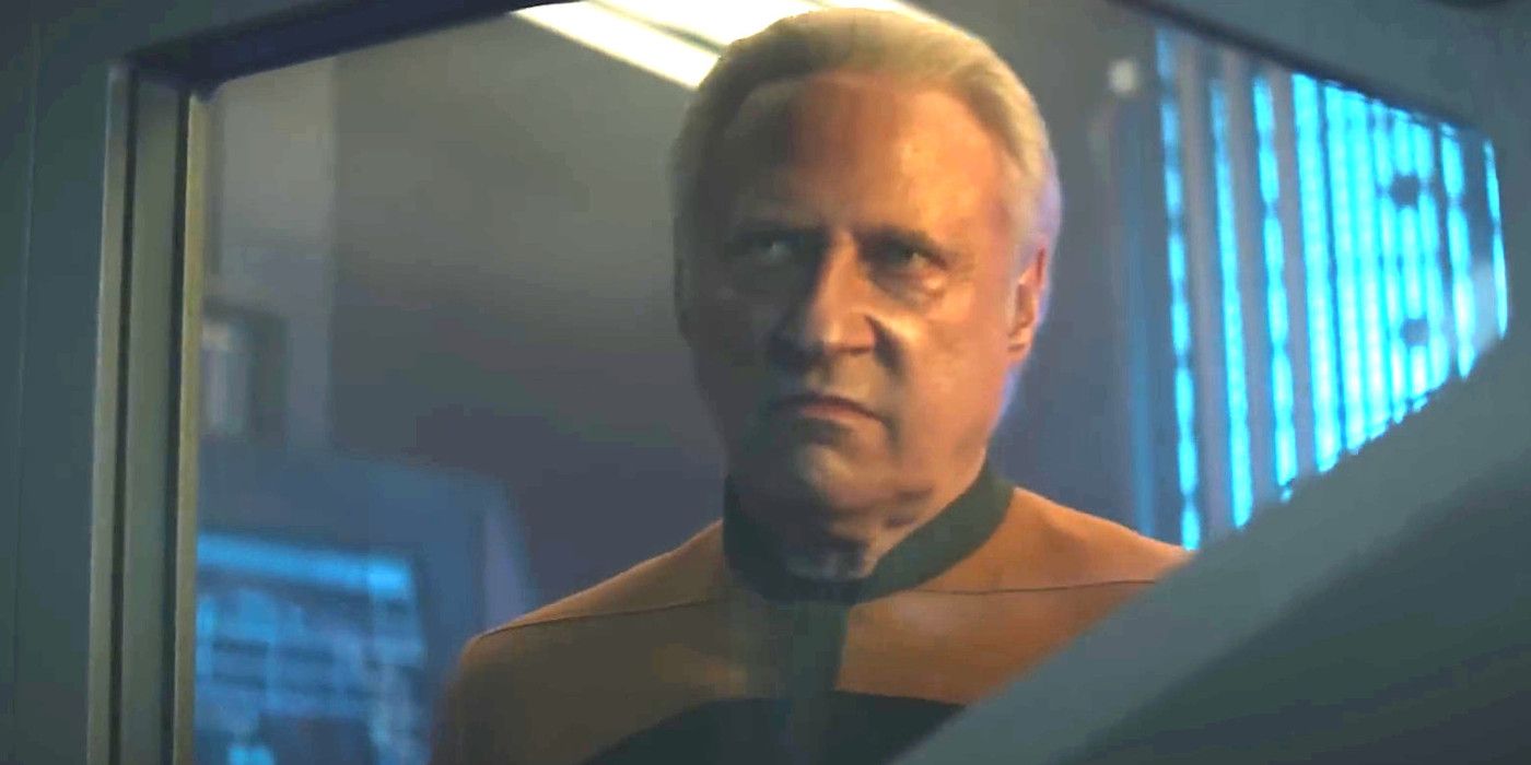 Brent Spiner As Lore In Picard Season 3 dressed in a TNG-era Starfleet uniform and sneering through a window