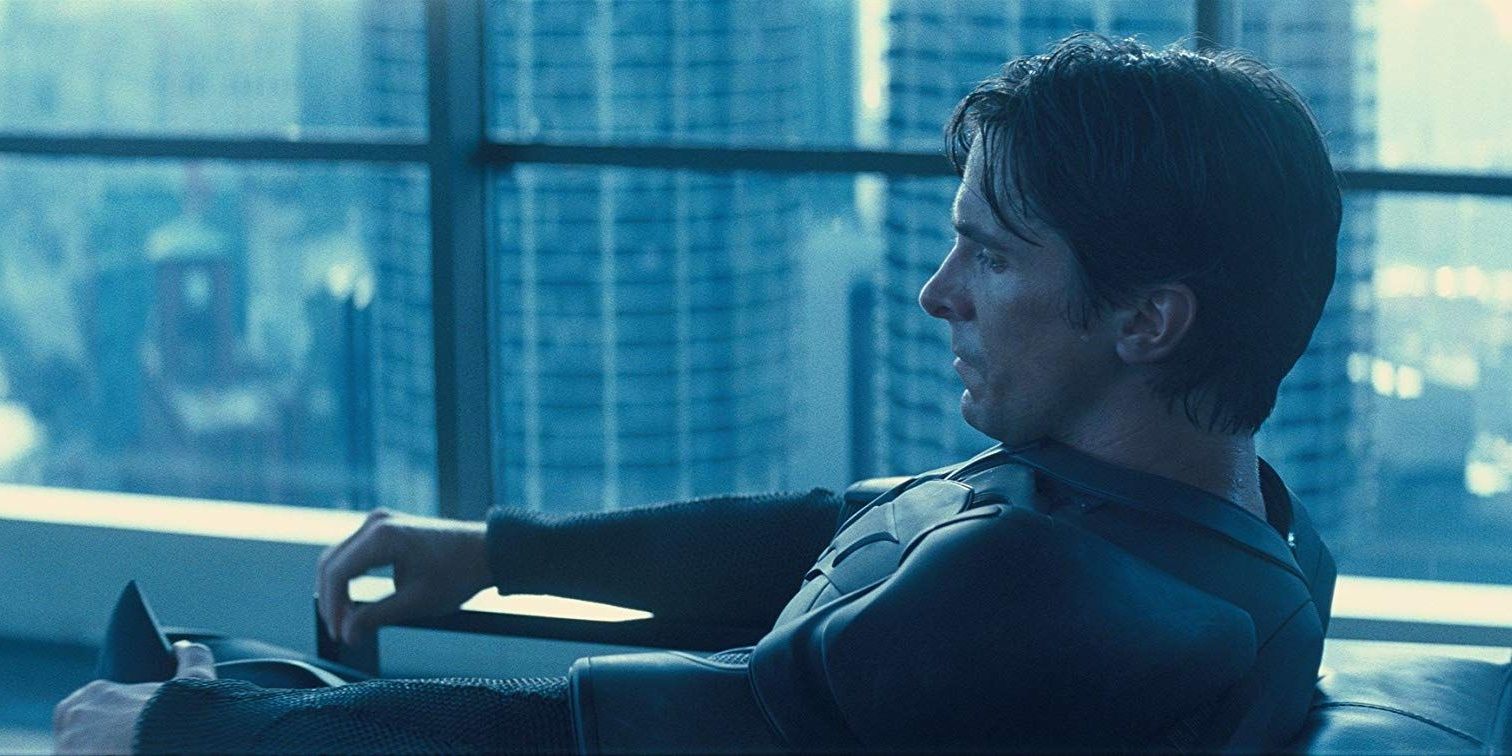 Bruce Wayne chorando em uma cadeira em O Cavaleiro das Trevas 